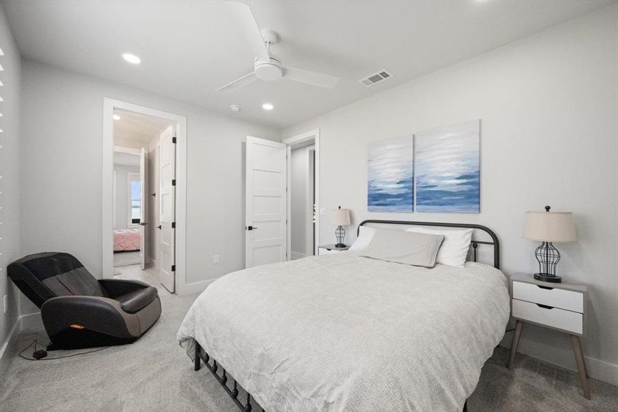 Carpeted bedroom with ceiling fan and recessed lighting