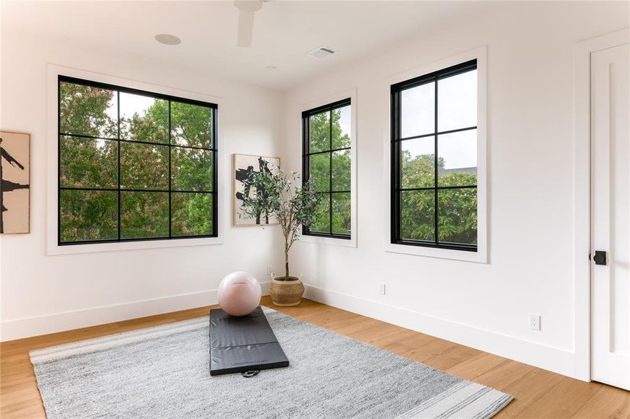 Exercise room featuring ceiling fan and wood finished floors
