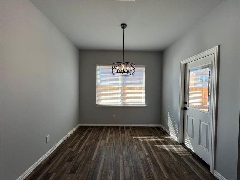 Unfurnished dining area with a chandelier and dark wood-type flooring