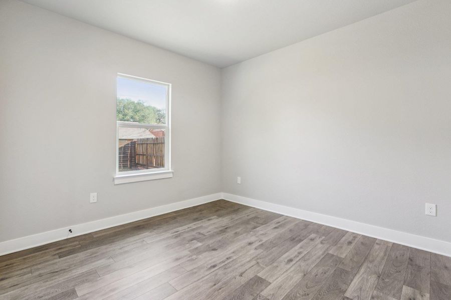 Spare room featuring wood finished floors and baseboards