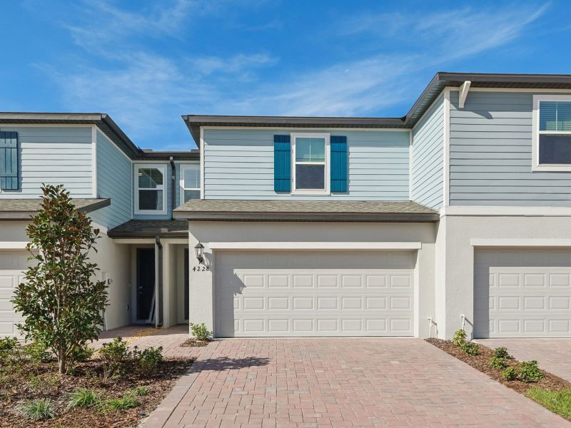 Front exterior of a new home in The Meadow at Crossprairie Townes, St. Cloud, FL, highlighting curb appeal (Image 1). Front exterior of a new home in The Meadow at Crossprairie Townes, St. Cloud, FL, highlighting curb appeal (Image 1).