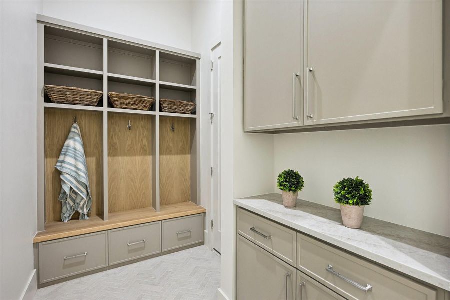 Even the drop zone gets the custom treatment, with built-in cubbies, bench seating, drawers and cabinetry designed to keep coats, bags and everyday essentials organized and out of the way.