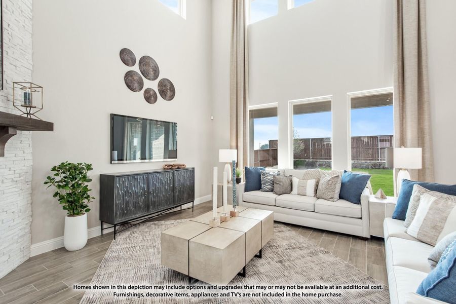 Living room with two-story ceiling, large windows, white sofas, and a stone fireplace wall Living room with two-story ceiling, large windows, white sofas, and a stone fireplace wall