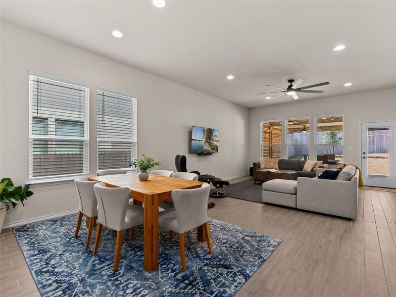 Dining space with wood tiled floors, ceiling fan, and recessed lighting