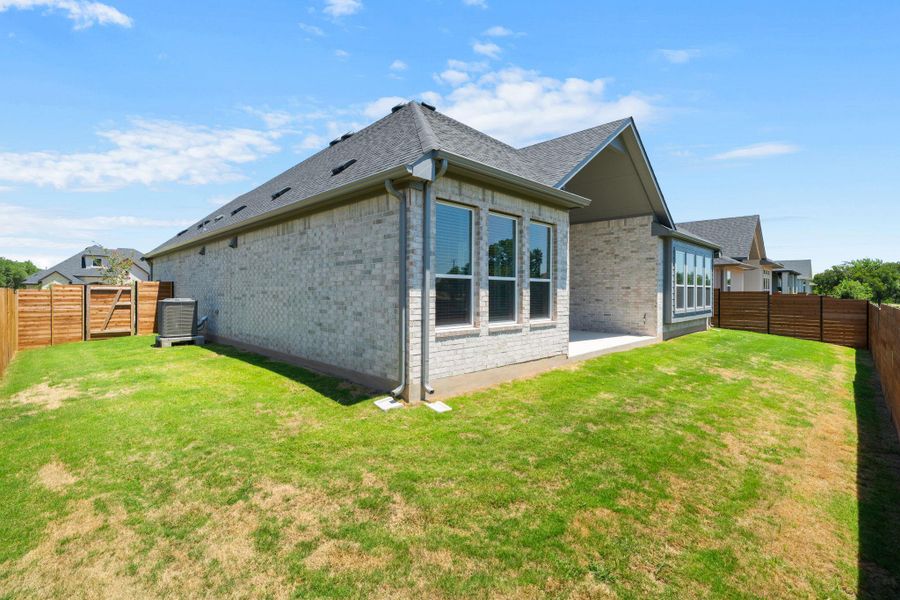 A fresh exterior with brick siding, a private yard, and a charming back patio awaits.