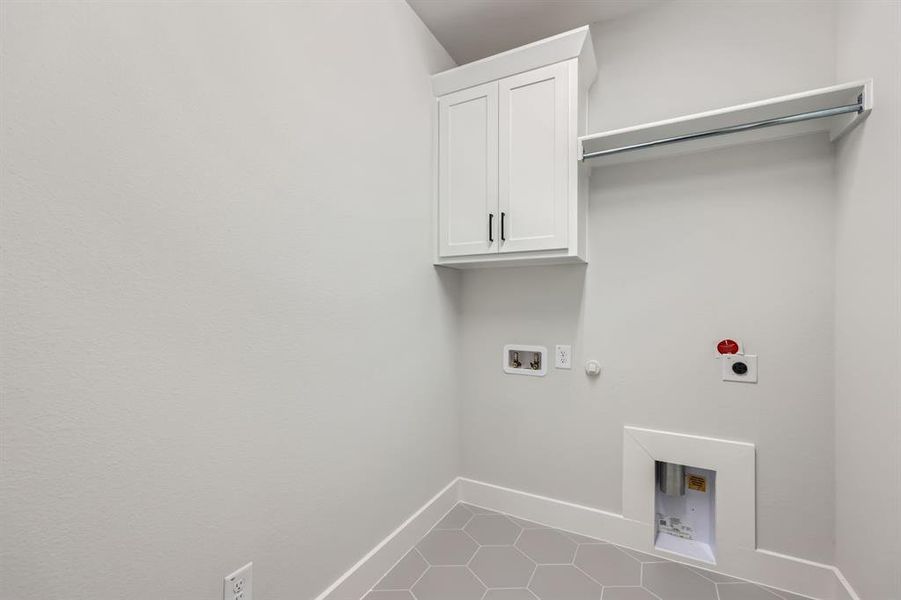 Laundry area with hookup for an electric dryer, hookup for a washing machine, cabinets, gas dryer hookup, and tile patterned flooring