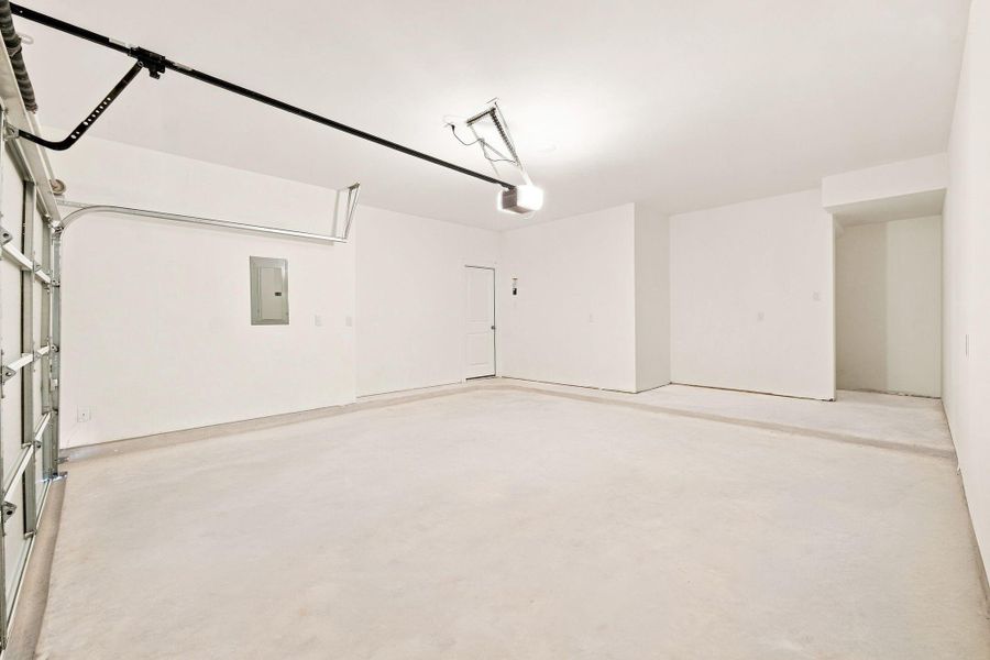 Spacious attached garage featuring a generous dedicated storage area, providing valuable extra room for tools, equipment, seasonal items and everyday storage needs. Spacious attached garage featuring a generous dedicated storage area, providing valuable extra room for tools, equipment, seasonal items and everyday storage needs.