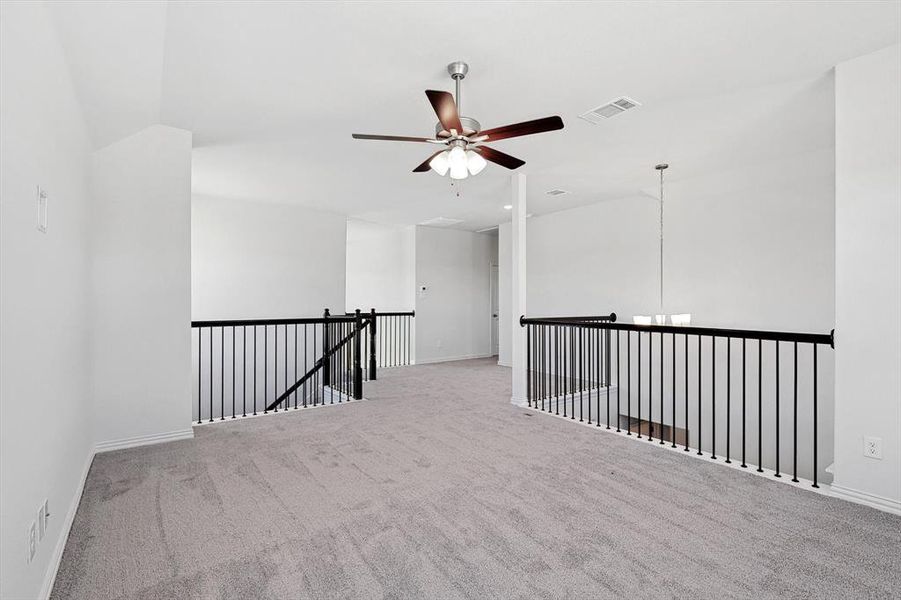 Unfurnished room featuring lofted ceiling, ceiling fan, and light carpet