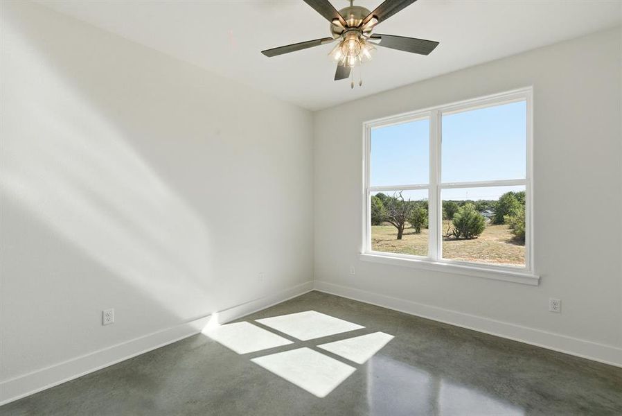 Empty room featuring baseboards and finished concrete floors