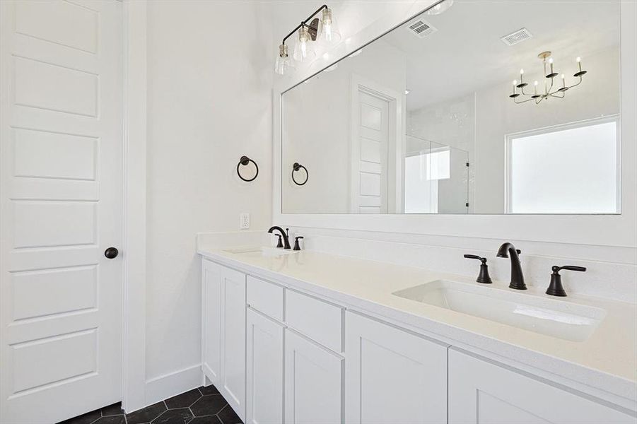 Primary Bathroom featuring vanity, a chandelier, tile patterned flooring, and an enclosed shower