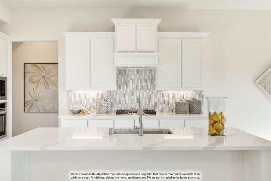 Kitchen with white cabinets, marble tile backsplash, quartz island, and undermount sink
