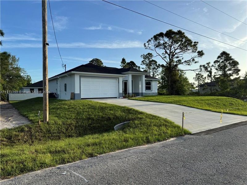 Front exterior of a new home in , Lehigh Acres, FL, highlighting curb appeal (Image 15).