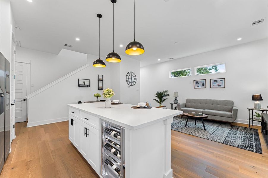 This centrally positioned kitchen island serves as a stylish anchor within the open-concept layout, offering clear sightlines to the dining area, living space, and the backyard beyond. Its placement encourages seamless interaction, whether prepping meals or entertaining guests, while natural light pours in through the nearby windows. The island’s sleek design and functional surface make it a hub of activity, framed by elegant finishes tying together comfort and sophistication.