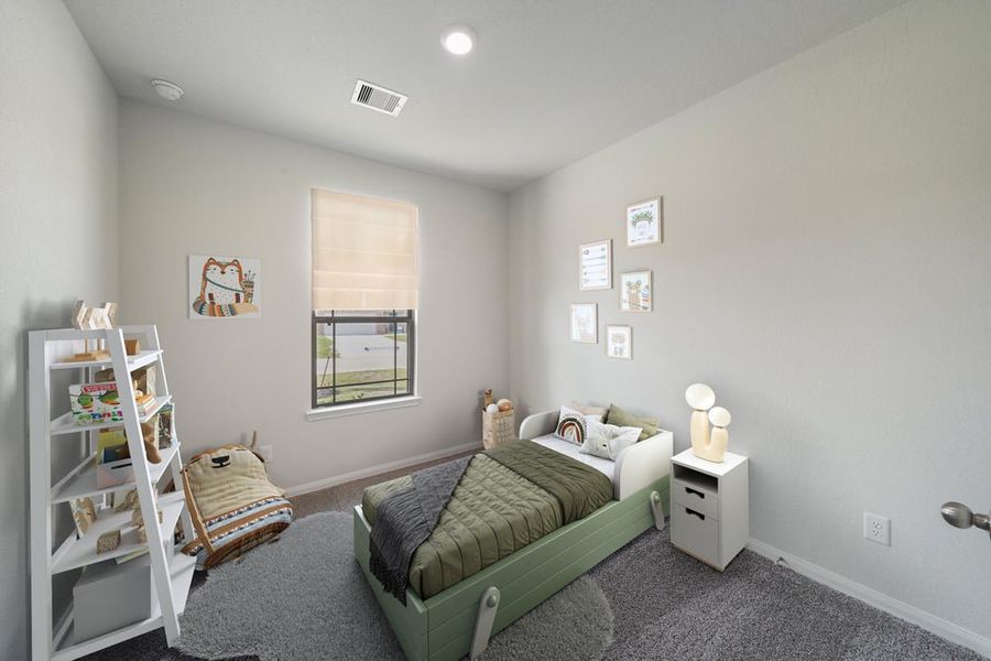 Child's bedroom with green toddler bed, gray carpet, white bookshelf, and framed wall art Child's bedroom with green toddler bed, gray carpet, white bookshelf, and framed wall art