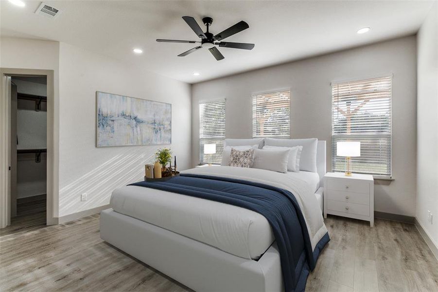 Bedroom featuring a walk in closet, light wood-style flooring, recessed lighting, and a ceiling fan Bedroom featuring a walk in closet, light wood-style flooring, recessed lighting, and a ceiling fan