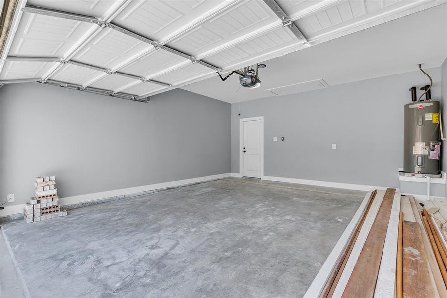 Garage featuring water heater and a garage door opener