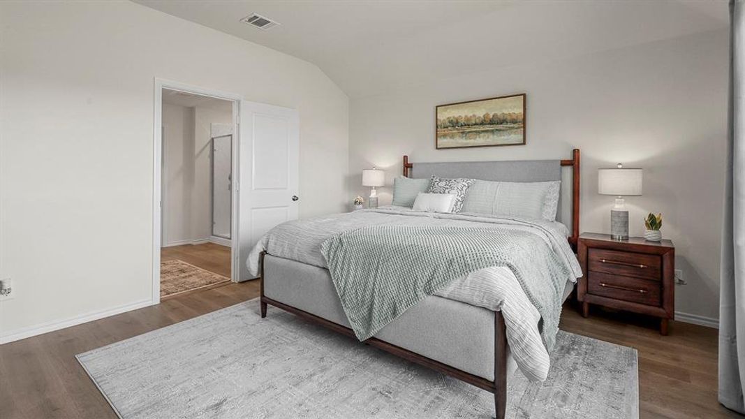 This bedroom features wood-look flooring and light-colored walls