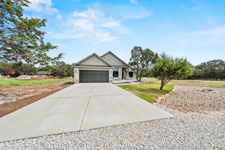 View of front facade with concrete driveway, a garage, and board and batten siding View of front facade with concrete driveway, a garage, and board and batten siding