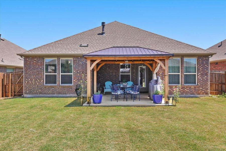 Rear view of property featuring a fenced backyard, brick siding, a gazebo, and a patio Rear view of property featuring a fenced backyard, brick siding, a gazebo, and a patio