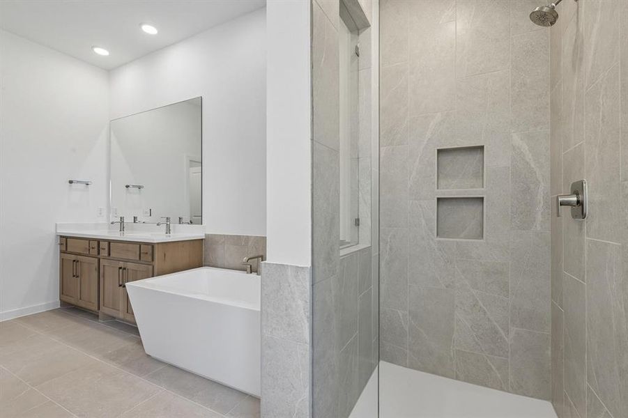 Full bath featuring double vanity, a walk in shower, a freestanding tub, light tile patterned flooring, and recessed lighting Full bath featuring double vanity, a walk in shower, a freestanding tub, light tile patterned flooring, and recessed lighting