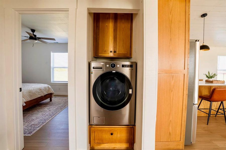 Laundry area featuring a stackable washer and dryer, complemented by wood cabinetry
