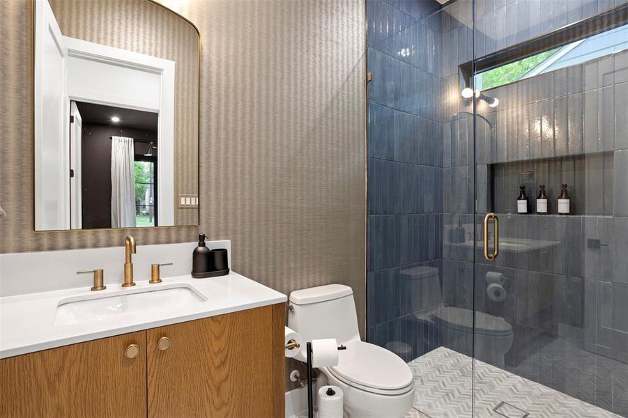 Bathroom featuring a single vanity with wood-finish cabinetry, a white countertop, and gold-tone fixtures