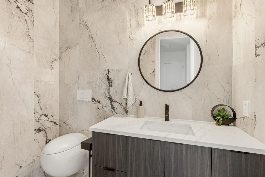 Modern bathroom vanity featuring a rectangular undermount sink, a sleek black faucet, and a circular framed mirror