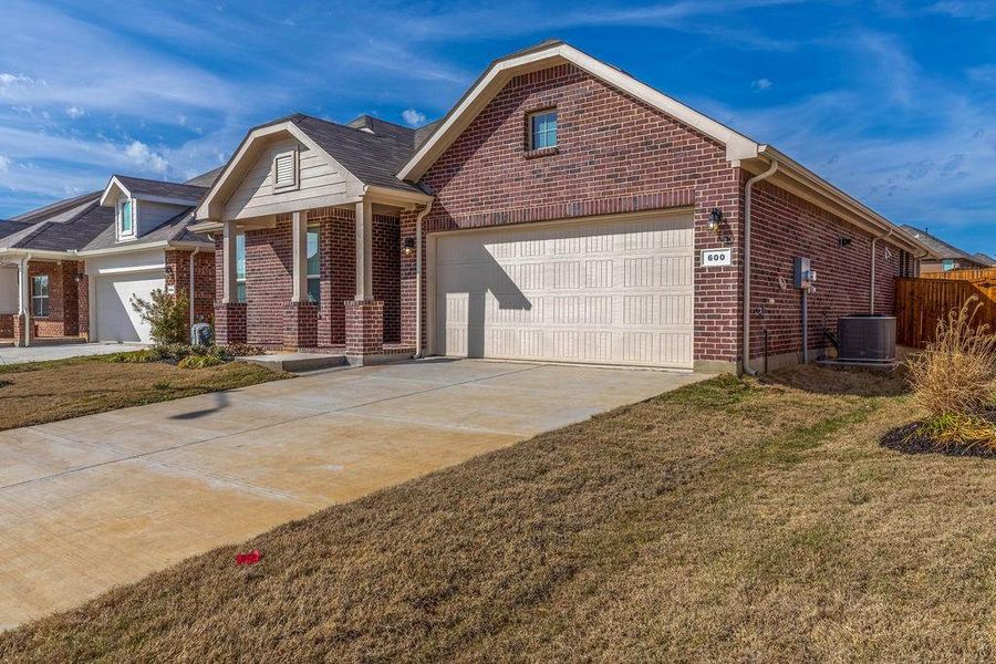 Ranch-style house with brick siding, driveway, covered porch, and a front lawn Ranch-style house with brick siding, driveway, covered porch, and a front lawn