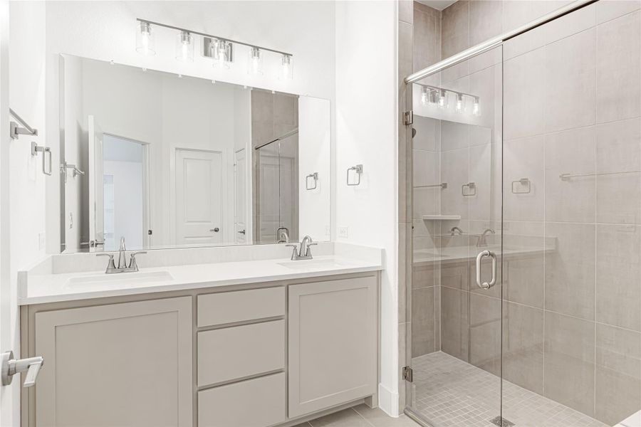 Bathroom with double sink vanity, large mirror, and glass-enclosed walk-in shower with tile walls