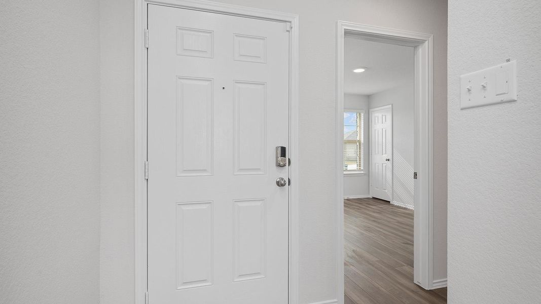 Entrance foyer featuring dark wood-style floors and a textured wall