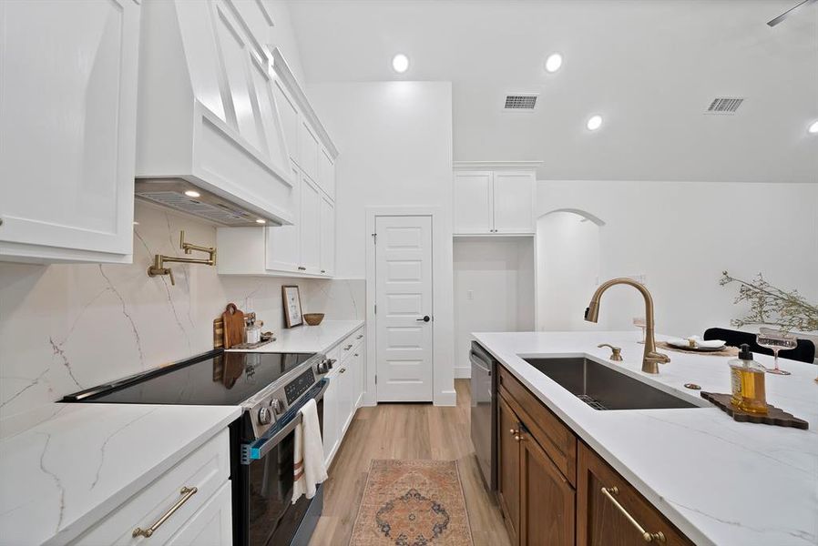 Modern kitchen with white cabinetry and a contrasting wood-finish island Modern kitchen with white cabinetry and a contrasting wood-finish island