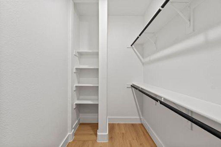 Spacious closet with light hardwood / wood-style flooring