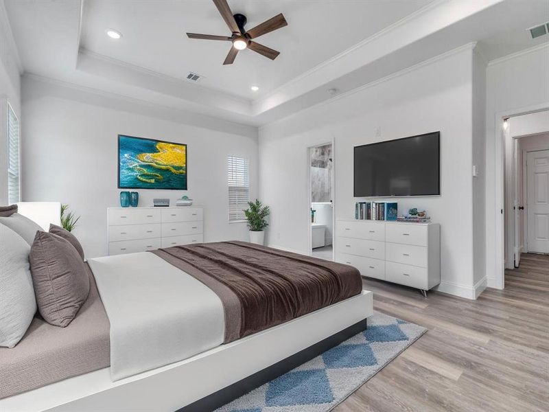 Bedroom with a raised ceiling, light wood-style floors, ceiling fan, ornamental molding, and recessed lighting Bedroom with a raised ceiling, light wood-style floors, ceiling fan, ornamental molding, and recessed lighting