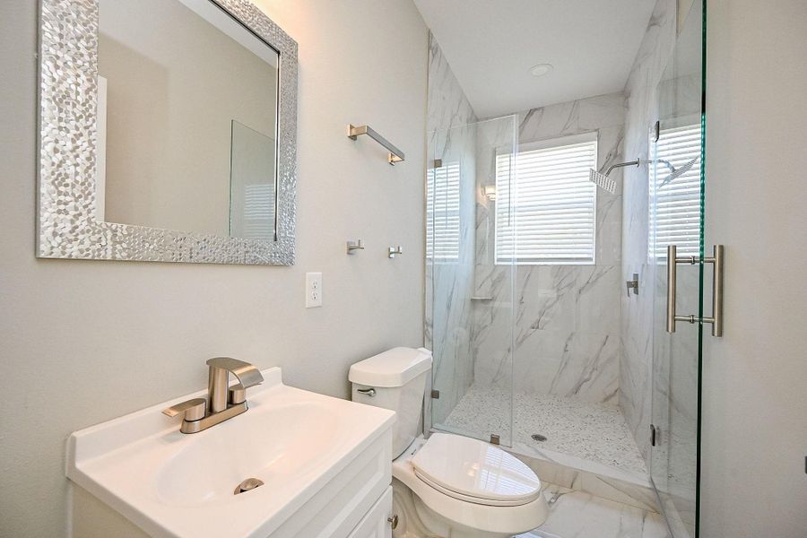 Secondary bathroom with stylish tile surround in shower.
