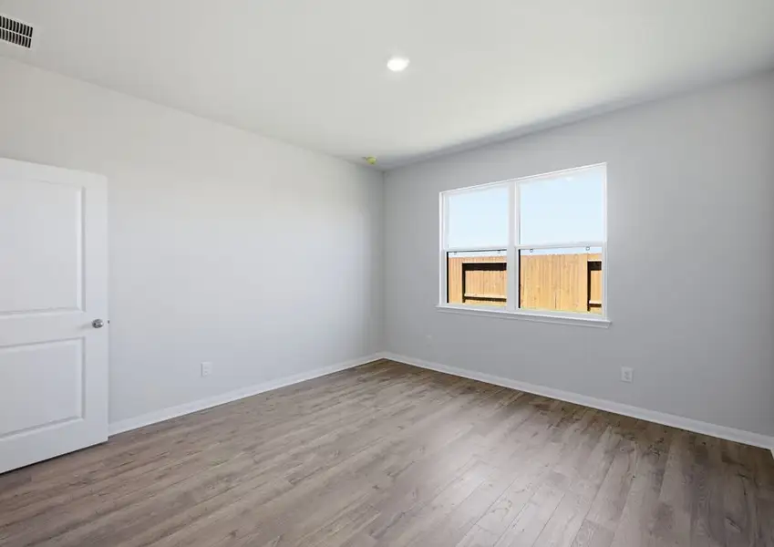 Primary bedroom with window and vinyl flooring in Montgomery floor plan