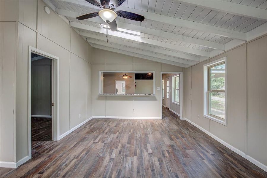 Unfurnished living room with wood ceiling, ceiling fan, dark hardwood / wood-style floors, and vaulted ceiling with beams