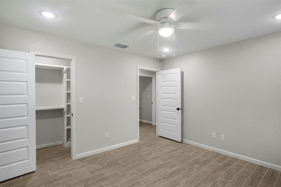 Unfurnished bedroom featuring recessed lighting, a spacious closet, a ceiling fan, and light wood-type flooring Unfurnished bedroom featuring recessed lighting, a spacious closet, a ceiling fan, and light wood-type flooring