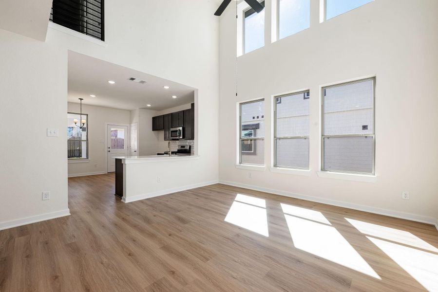 The impressive two-story living room offers a grand sense of space and light, thanks to soaring ceilings and a stunning bank of large windows that flood the area with natural light. The impressive two-story living room offers a grand sense of space and light, thanks to soaring ceilings and a stunning bank of large windows that flood the area with natural light.