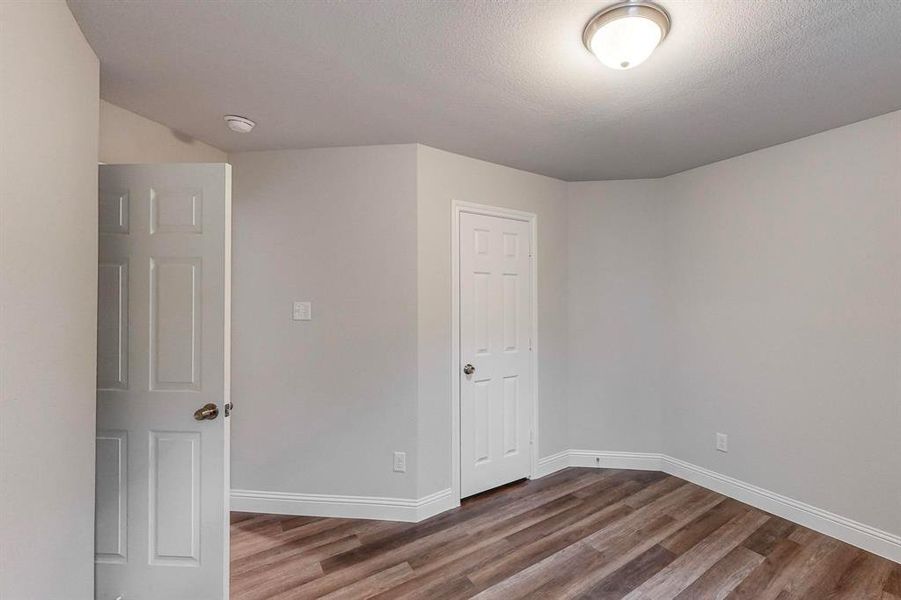 Spare room featuring wood-type flooring and a textured ceiling