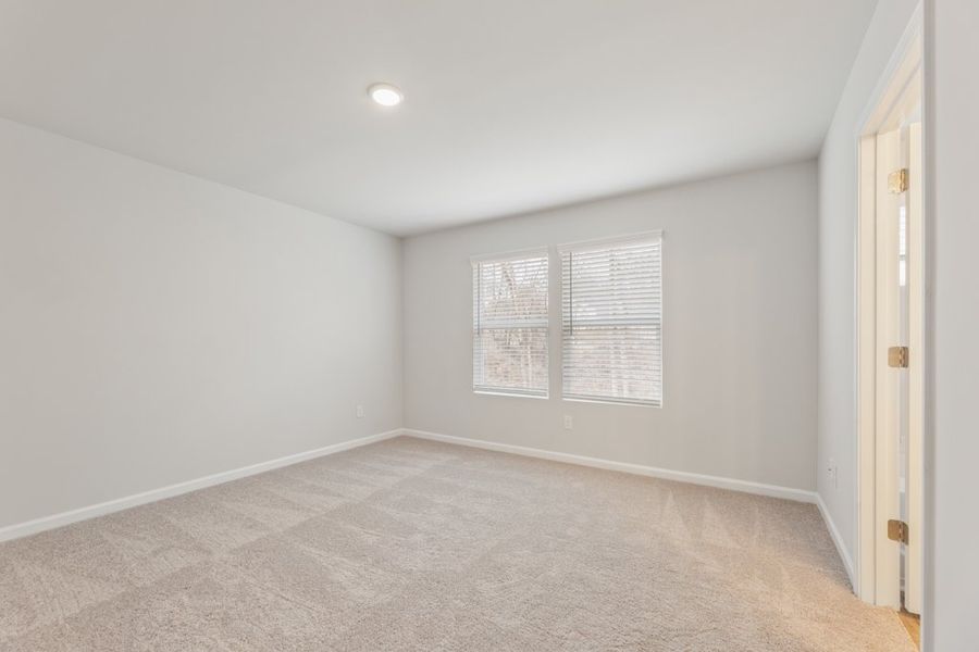A room with a carpet and a light on the wall.