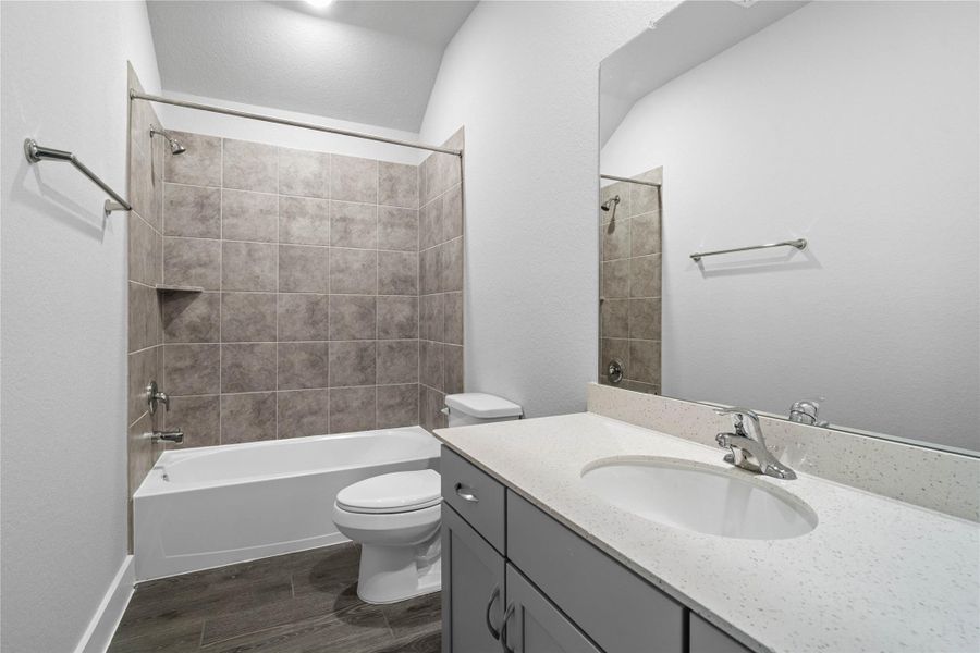 A streamlined secondary bathroom providing a functional tub/shower combination and modern fixtures, seamlessly blending practicality and style. A streamlined secondary bathroom providing a functional tub/shower combination and modern fixtures, seamlessly blending practicality and style.