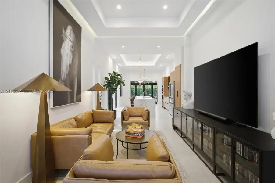 Tray ceilings with recessed lighting, large-format tile flooring, and a kitchen island featuring waterfall stone countertops