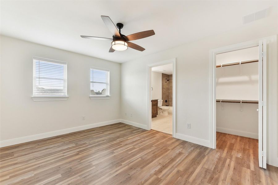 Bedroom 2 bedroom with a spacious closet, light wood look floors, visible vents, a closet, and baseboards Bedroom 2 bedroom with a spacious closet, light wood look floors, visible vents, a closet, and baseboards