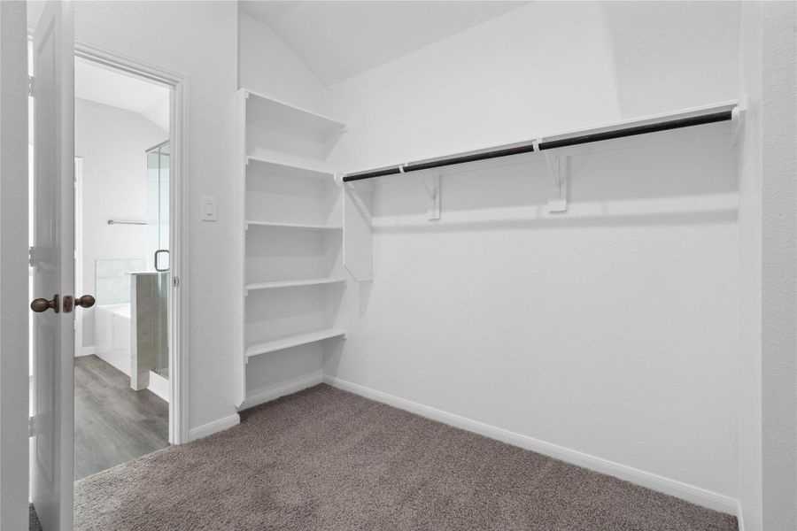 The primary suite features a generous walk-in closet equipped with functional hanging rods and shelving. The primary suite features a generous walk-in closet equipped with functional hanging rods and shelving.