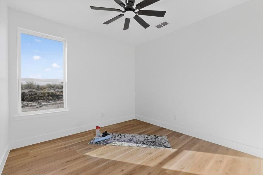 Spare room featuring light wood-style flooring and a ceiling fan Spare room featuring light wood-style flooring and a ceiling fan