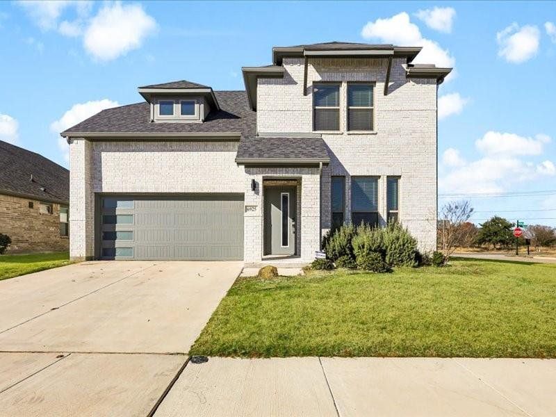 View of front facade featuring a front lawn and a garage