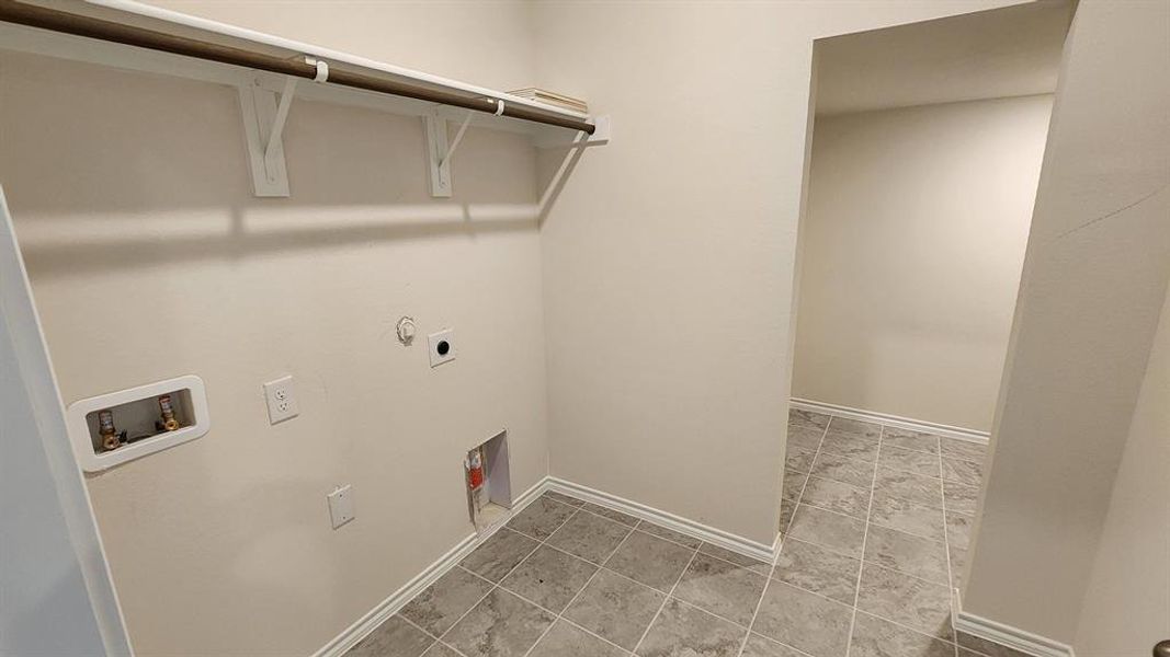Dedicated laundry area with tile flooring and a built-in hanging rod Dedicated laundry area with tile flooring and a built-in hanging rod