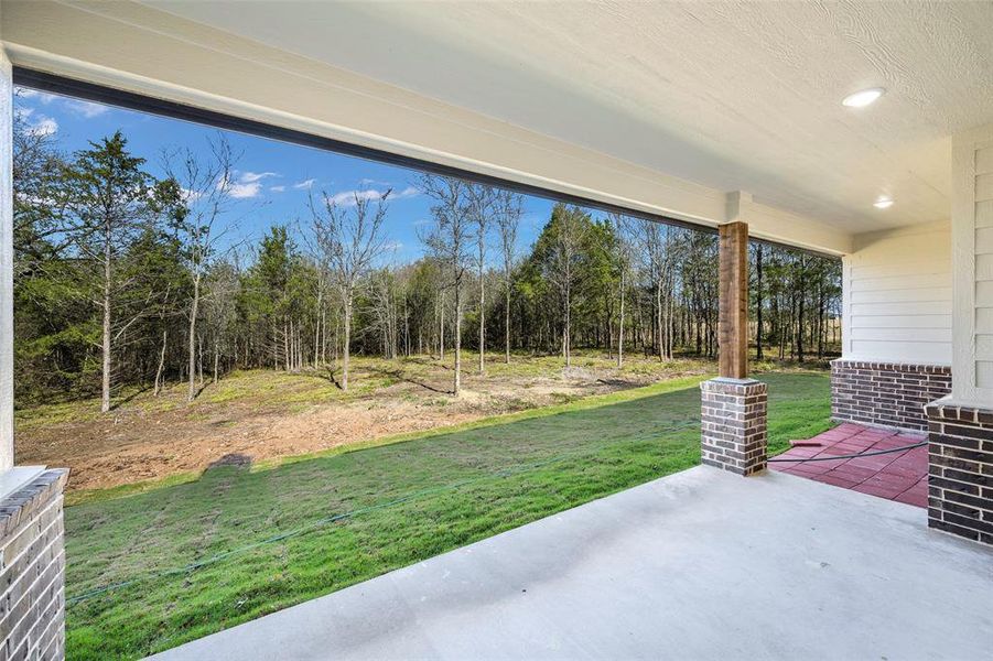 Tucked away in a canopy of mature trees, this charming home is a hidden gem. Expansive covered back patio showcasing the property's remarkable wooded backdrop. Quality construction details include brick columns with cedar accents and recessed lighting.