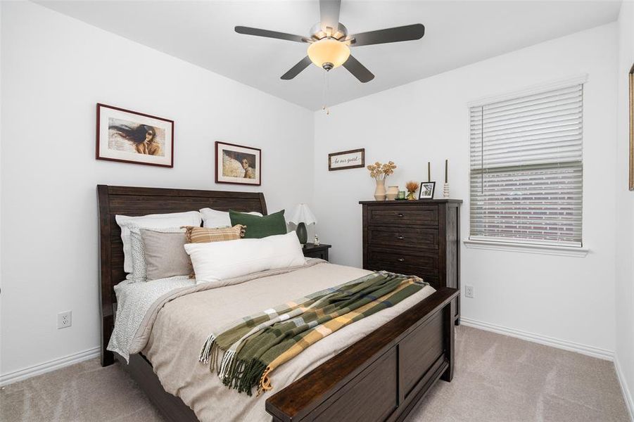 This room features a ceiling fan with integrated lighting, a window with blinds, and light-colored carpeting