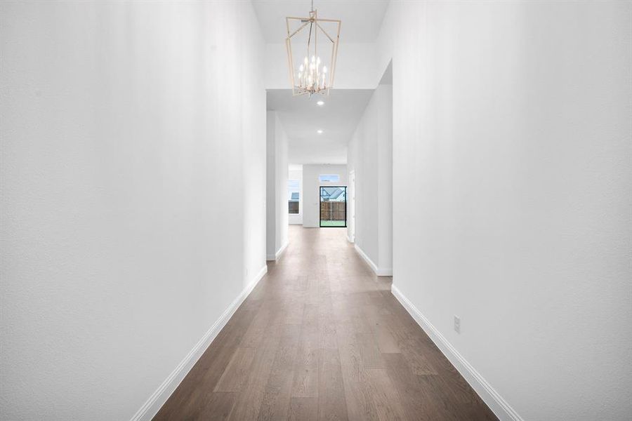 Elegant entry with hardwood / wood-style flooring and a chandelier